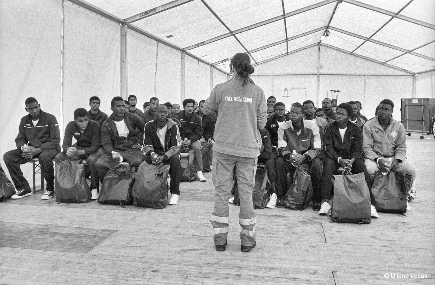 Un'operatrice della Croce Rossa spiega l'organizzazione del Centro Fenoglio a rifugiati richiedenti asilo appena arrivati nella struttura, Settimo, 2017