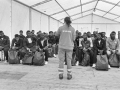 Un'operatrice della Croce Rossa spiega l'organizzazione del Centro Fenoglio a rifugiati richiedenti asilo appena arrivati nella struttura, Settimo, 2017